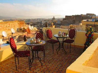 a balcony with tables and chairs with a view at Dar Hafsa in Fès
