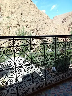 a black fence with a mountain in the background at Hôtel Restaurant La Gazelle De Dades in Akhendachou nʼAït Ouffi