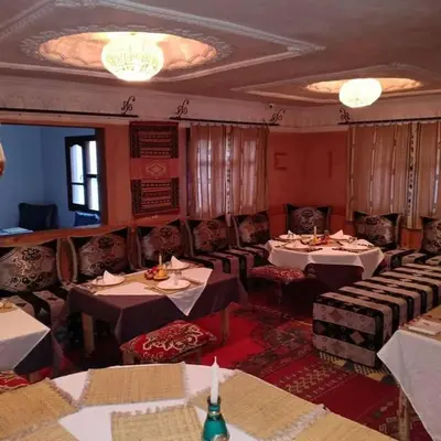 a restaurant with tables and chairs in a room at Hôtel Restaurant La Gazelle De Dades in Akhendachou nʼAït Ouffi
