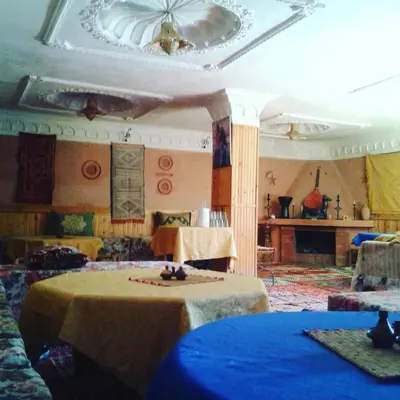 a room with two tables and a ceiling at Hôtel Restaurant La Gazelle De Dades in Akhendachou nʼAït Ouffi