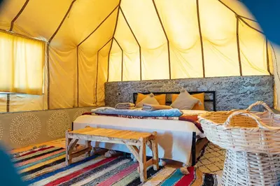a bedroom with two beds in a tent at Tinfou desert camp in Beni Ali