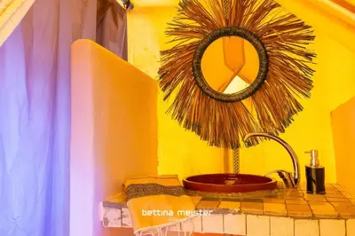 a bathroom with a sink and a mirror on the wall at Tinfou desert camp in Beni Ali