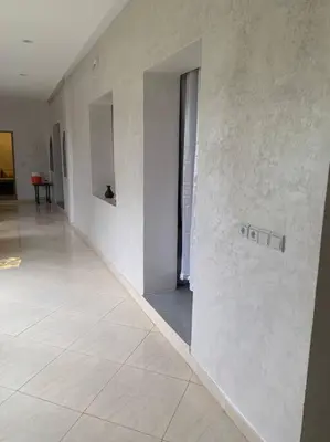 a hallway with white walls and a sign on a wall at Maison moalem in Marrakech