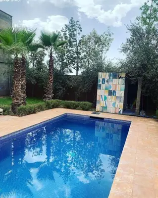 a swimming pool in a yard with palm trees at Maison moalem in Marrakech