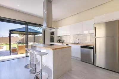 a kitchen with white cabinets and a large window at Villa Sanna, élégante avec piscine Chauffée, jeux in Marrakech