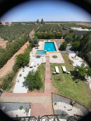 an aerial view of a swimming pool in a field at Maison unique avec une magnifique piscine in El Kelaa des Srarhna