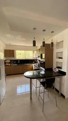 a kitchen with a table in the middle of a room at Maison unique avec une magnifique piscine in El Kelaa des Srarhna