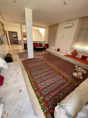 a living room with a large rug on the floor at Maison unique avec une magnifique piscine in El Kelaa des Srarhna