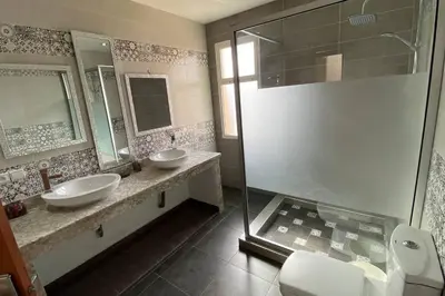 a bathroom with two sinks and a shower at Maison unique avec une magnifique piscine in El Kelaa des Srarhna