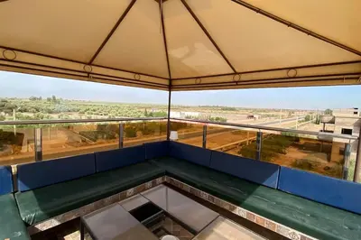 a balcony of a building with a view of a field at Maison unique avec une magnifique piscine in El Kelaa des Srarhna