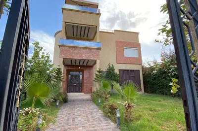 a house with a walkway in front of a building at Maison unique avec une magnifique piscine in El Kelaa des Srarhna
