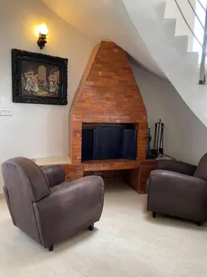 a living room with two chairs and a fireplace at Maison unique avec une magnifique piscine in El Kelaa des Srarhna