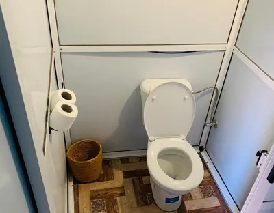 a small bathroom with a toilet and a roll of toilet paper at Merzouga Magic Carpet camp in Merzouga
