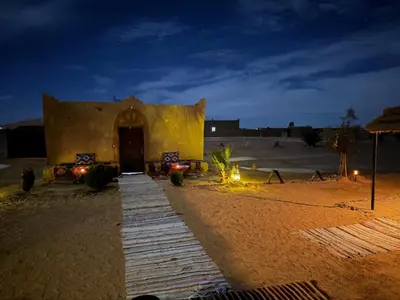a building in the middle of a desert at night at Camp Familia Erg Chebbi in Merzouga