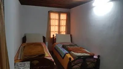 a small room with two beds and a window at Dar zerhane in Fès