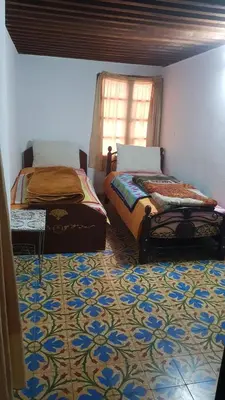 two beds in a room with a patterned floor at Dar zerhane in Fès
