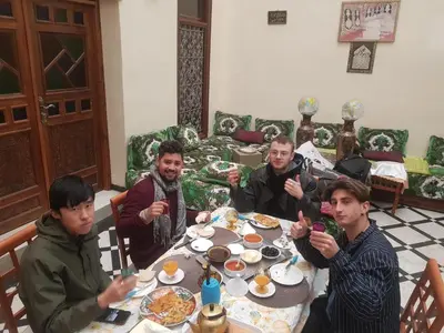 a group of men sitting around a table eating food at Dar zerhane in Fès