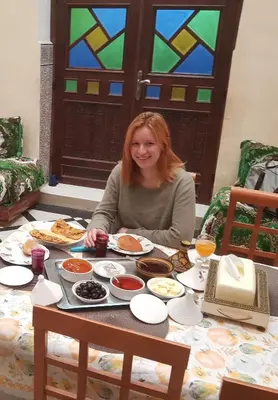 a woman sitting at a table full of food at Dar zerhane in Fès