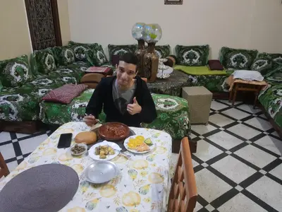 a man sitting at a table with a plate of food at Dar zerhane in Fès