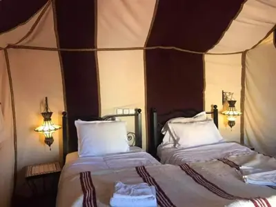 a bedroom with two beds in a tent at Merzouga luxury magic nights in Merzouga