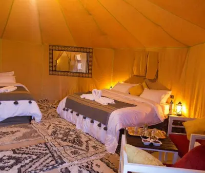 a bedroom with two beds in a tent at Merzouga luxury magic nights in Merzouga