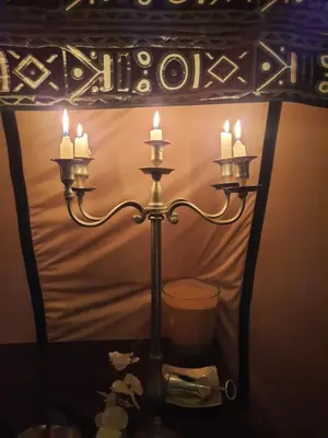 a candle holder with three lit candles on a table at Merzouga Majestic Camp in Merzouga