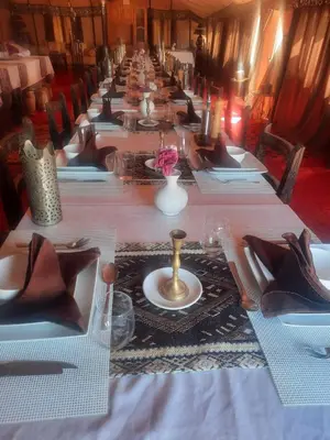 a long table is lined up in a row at Merzouga Majestic Camp in Merzouga