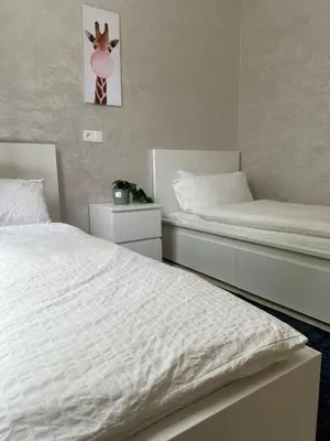a bedroom with two twin beds and a clock on the wall at Ifrane apartment with swimming pool in Ifrane