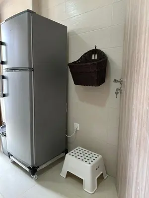 a refrigerator in a kitchen with a basket on the wall at Ifrane apartment with swimming pool in Ifrane