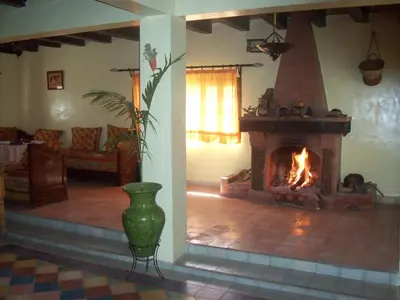 a living room with a fireplace and a couch at Safranière du M' Goun in Aguerd nʼOuzrou