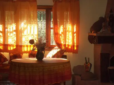 a table with a vase on it in a room with windows at Safranière du M' Goun in Aguerd nʼOuzrou