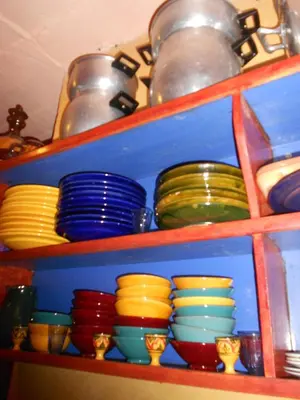 a shelf filled with colorful plates and bowls at Safranière du M' Goun in Aguerd nʼOuzrou