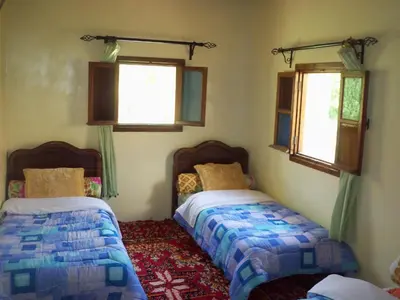 a bedroom with two beds and two windows at Safranière du M' Goun in Aguerd nʼOuzrou