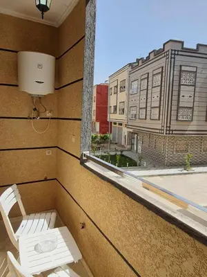 a window with a white chair and a building at Appartement Dar Meknès in Meknès