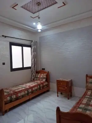 a living room with two beds and a window at Appartement Dar Meknès in Meknès
