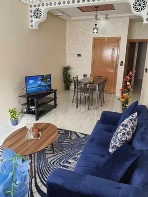 a living room with a blue couch and a table at Appartement Dar Meknès in Meknès