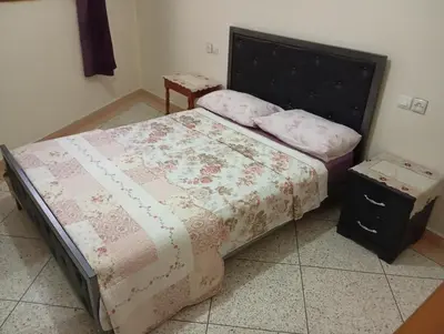 a bedroom with a large bed and a night stand at Chez-soi in Meknès