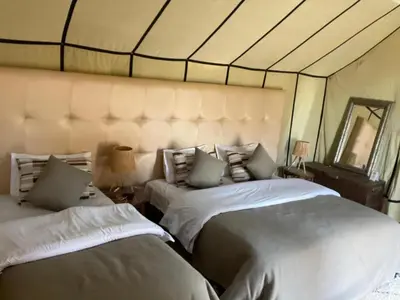 a bedroom with two beds and a mirror at Arena Desert Camp & Activitys in Merzouga