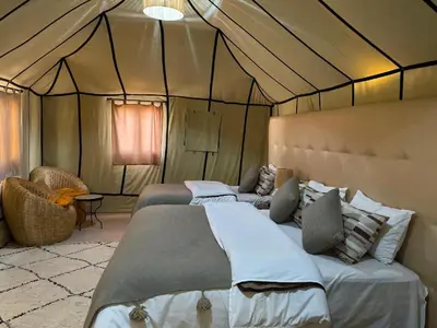 a bedroom with two beds in a tent at Arena Desert Camp & Activitys in Merzouga
