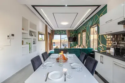 a dining room with a white table and chairs at villa Safa, confort et relax, piscine Chauffée, hammam in Marrakech