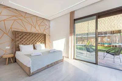 a bedroom with a bed and a large window at villa Safa, confort et relax, piscine Chauffée, hammam in Marrakech