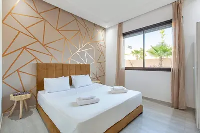 a bedroom with a large bed with a geometric wall at villa Safa, confort et relax, piscine Chauffée, hammam in Marrakech