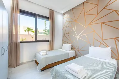 a room with two beds and a window at villa Safa, confort et relax, piscine Chauffée, hammam in Marrakech