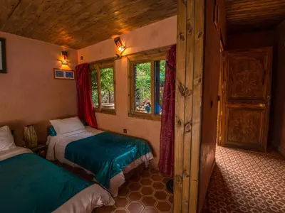 a bedroom with two beds in a room with windows at Hotel Bin El Ouidane in Bine el Ouidane
