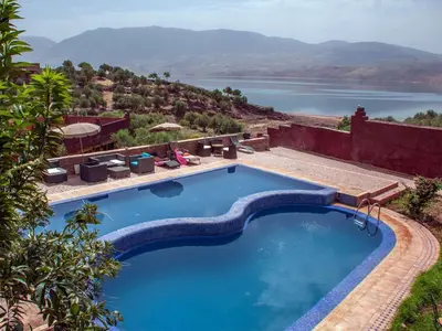 a swimming pool with a view of the water at Hotel Bin El Ouidane in Bine el Ouidane
