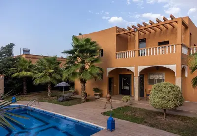 a house with a swimming pool in front of it at Oasis Oumifis in Marrakech