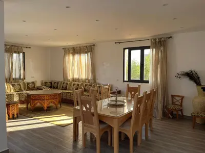 a living room with a table and a couch at Oasis Oumifis in Marrakech