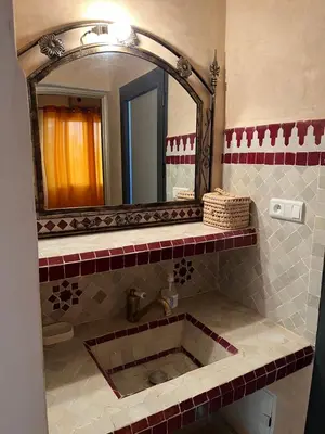 a bathroom with a sink and a large mirror at Oasis Oumifis in Marrakech