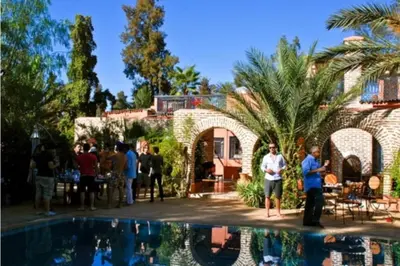 a group of people standing next to a swimming pool at Villa Yasmina in Douar Blidene