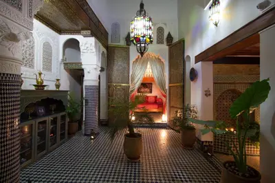 a room with a bed and potted plants in it at Riad Sanaa Rose in Fès